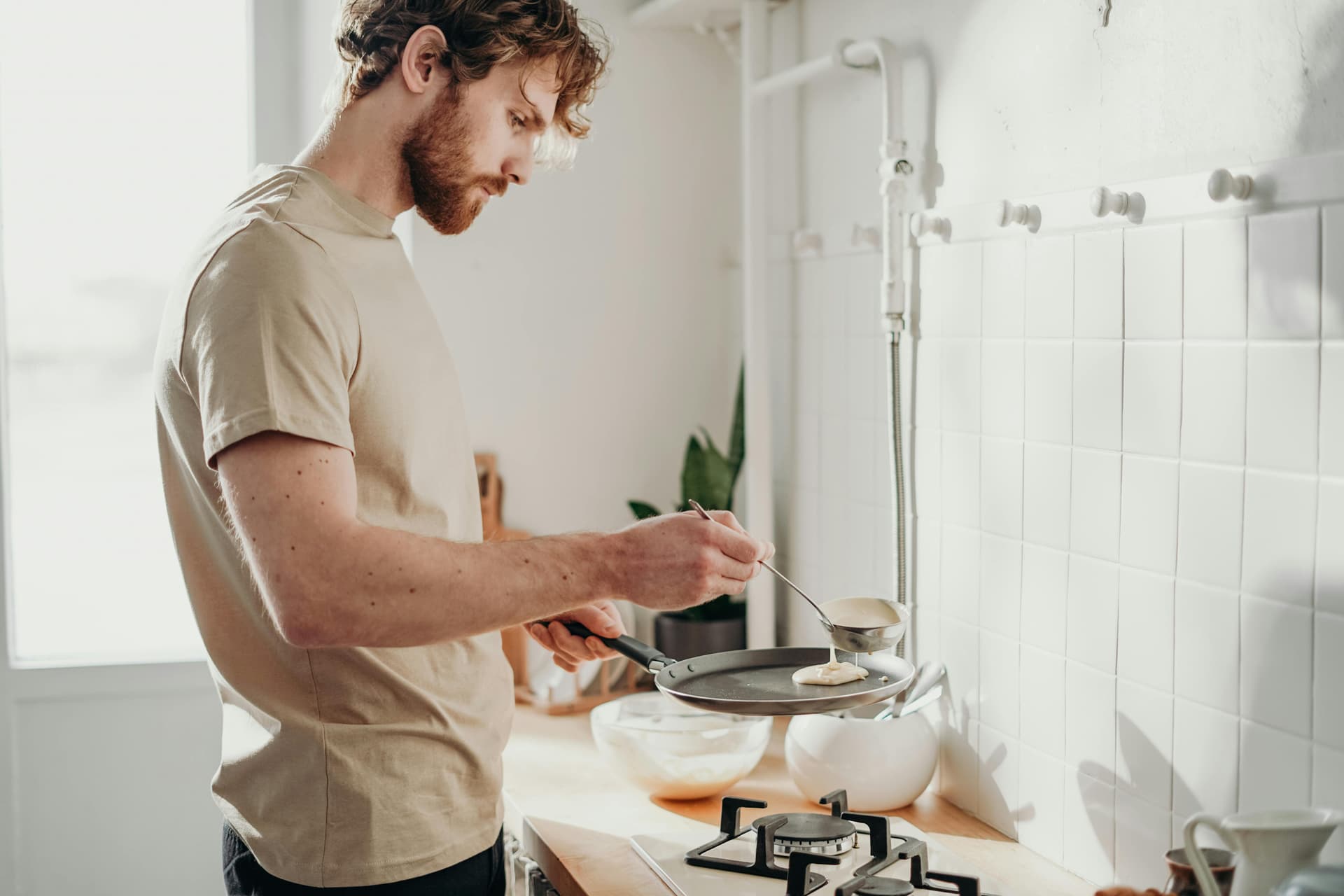 Traveler preparing a budget meal in a hostel kitchen