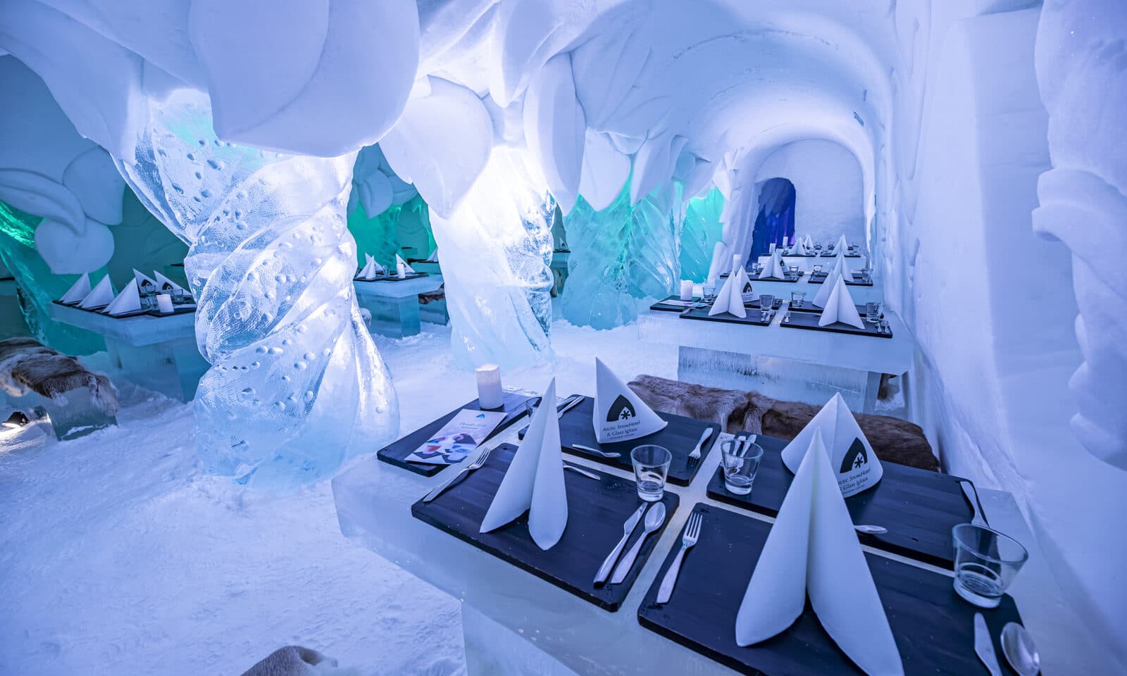 Guests dining on ice tables inside a frozen restaurant in Finland